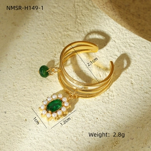 Detail of vintage gold layered ring with green stone pendant and small pearls