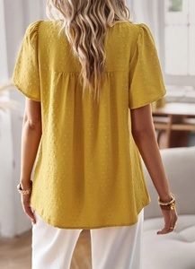 Detail of yellow short-sleeve shirt with textured fabric and pleated back design