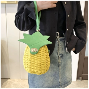Detail of pineapple woven bucket bag with metal lock and green leaf handle design