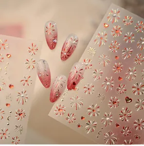 Detail of festive heart and fireworks nail art stickers with red gradient finish