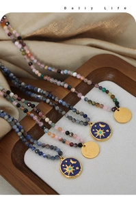 Detail of handmade beaded necklaces with celestial enamel charms and angel relief pendants