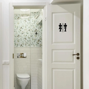 Funny matte black PVC restroom sign sticker with man and woman icons on a white door