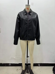 Close-up of black faux leather bomber jacket featuring lapel collar and metal zipper detail