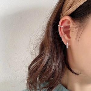 Detailed view of sterling silver hammered texture ear cuffs and studs worn on ear