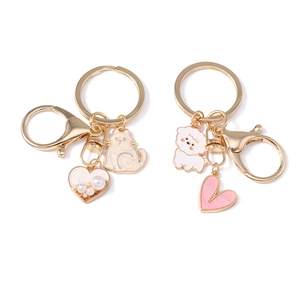 Cute cartoon cat and dog metal keychains with heart and pearl charms on white background