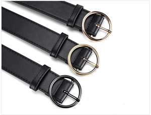 Detailed view of women's black PU belts with gold, bronze and black round buckles
