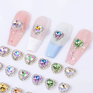Faceted heart-shaped nail art rhinestones with silver metal borders and aurora finish