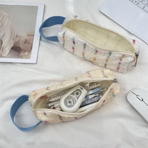 Detail of floral tweed pencil cases with blue handles showing large storage capacity