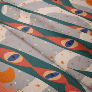 Detailed close-up of Bohemian tapestry fabric with retro eye pattern and velvet texture