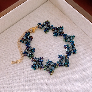 Détail macro d'un bracelet fleuri en perles bleu foncé avec un fermoir doré brillant