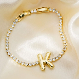 Luxurious gold-plated letter K bracelet with sparkling zircon stones on champagne satin