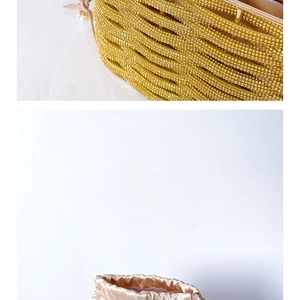 Detailed macro of golden rhinestone evening bag with champagne satin lining and pearls