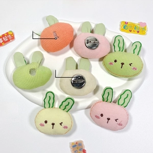 Detailed view of plush rabbit brooches in macaron colors with back safety pin closure