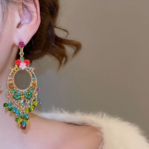 Close-up of Bohemian floral crystal tassel earrings with colorful beads on a gold base