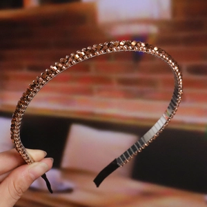 Close-up of handmade beaded headband featuring sparkling crystals and a thin gold base