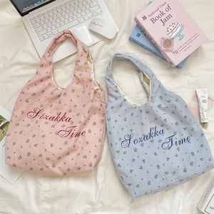 Flache Ansicht floraler Canvas-Tragetaschen in Rosa und Blau mit Aufdruck