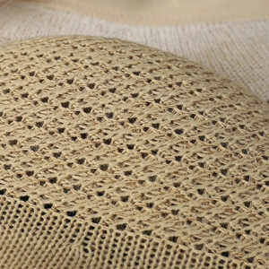 Detailed macro shot showing the hollow honeycomb knit texture of the beige sun hat