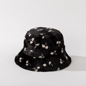 Close-up of fluffy faux fur bucket hat with white cherry pattern on black fabric