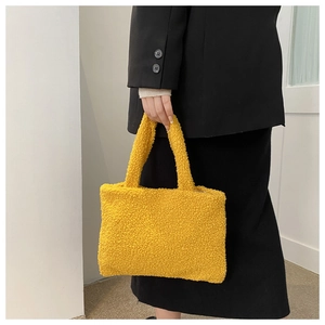 Detail showing soft yellow teddy plush fabric and texture of the women handbag