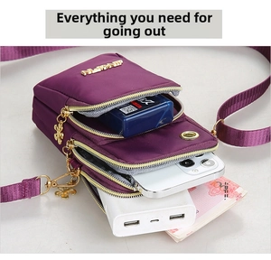 Detail view of the multi-layer purple nylon phone bag with gold zippers and large capacity