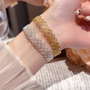 Détail des bracelets tissés creux entrelacés en finitions dorée et argentée