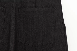 Dettaglio ravvicinato del tessuto denim nero e cuciture della tasca sui jeans