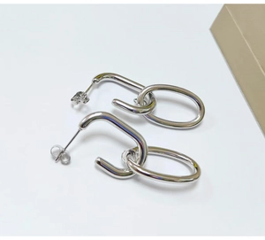Detailed view of silver minimalist interlocking chain hoop earrings in stainless steel