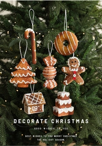 Detailed view of gingerbread man and candy cane ornaments hanging on a Christmas tree