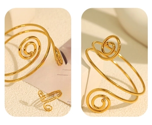 Detail of elegant gold spiral open bangle and matching ring set on fashion card