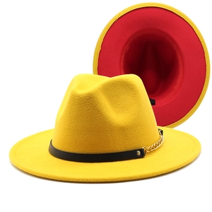 Detail of wool fedora hat featuring yellow crown, red brim, and gold chain accent