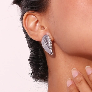 Détail de boucles d'oreilles vagues argentées avec perles blanches portées