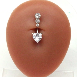 Detail of silver belly button ring with heart-shaped zircon on a mannequin model