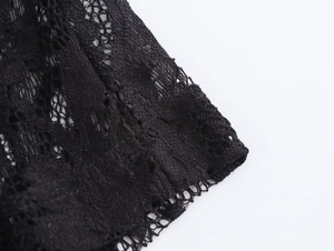 Close-up of elegant black floral lace fabric on dress sleeve with detailed embroidery