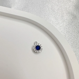 S925 sterling silver round pendant with blue gemstone and white zircon on a white tray