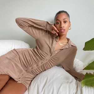 Detail view of brown button-down shirt dress featuring pleated waist and lapel collar