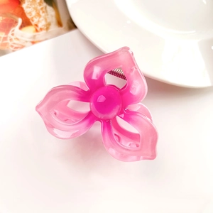 Detail showing the pink translucent resin flower hair claw clip with a glossy pearl center