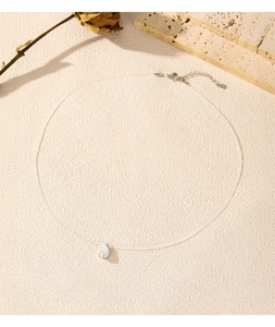 Detail of teardrop moissanite pendant on invisible fishing line necklace for women