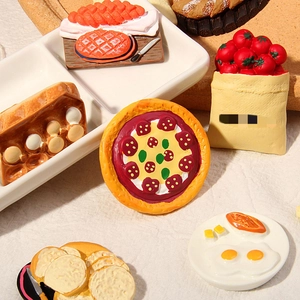 Creative collection of 3D resin miniature food fridge magnets on a beige fabric background