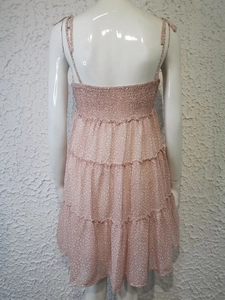 Détail d'une robe fleurie rose avec dos froncé élastique et fines bretelles