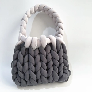 Close-up of charcoal gray and light gray chunky knit handmade handbag with thick yarn texture