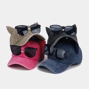 Dettaglio di cappellini da baseball con orecchie di gatto e occhiali in quattro colori
