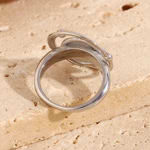 Macro shot of silver circular double-ring design on natural beige travertine stone