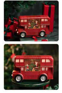 Detail of red Christmas bus snow globe with Santa Claus and a festive lit tree