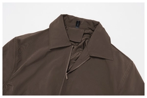 Close-up of deep brown windproof jacket featuring metal zipper and lapel collar details