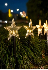 Close-up of star-shaped solar garden lights with warm white LED glow for outdoor lawn decor