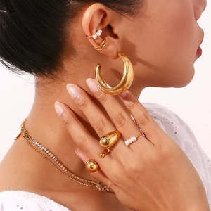 Detail shot of 18K gold plated water drop earrings and layered jewelry set on a model