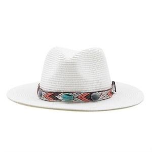 Détail d'un chapeau fedora en paille blanche avec ruban ethnique et pierres