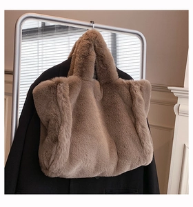 Vue détaillée d'un sac cabas en peluche marron doux suspendu à côté d'un blazer noir