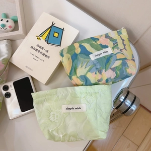 Detailed top view of floral and pale green jacquard mini makeup pouches with simple wish tags