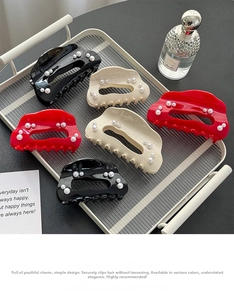 Elegant pearl shark hair clips set in black, cream and red on a display tray